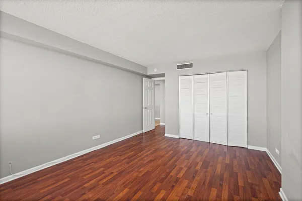 a view of an empty room with wooden floor