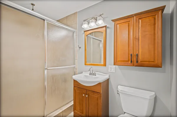 a bathroom with a granite countertop sink toilet and shower