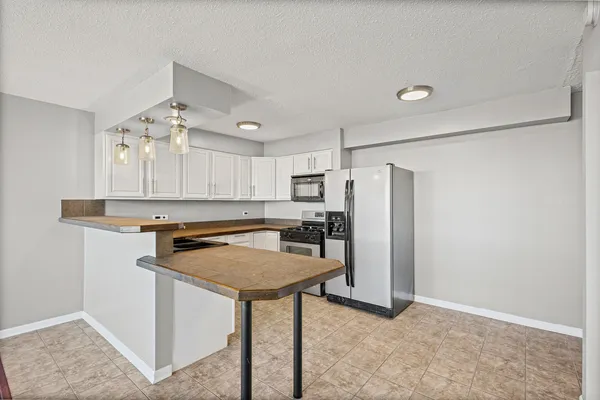 a kitchen with refrigerator and cabinets
