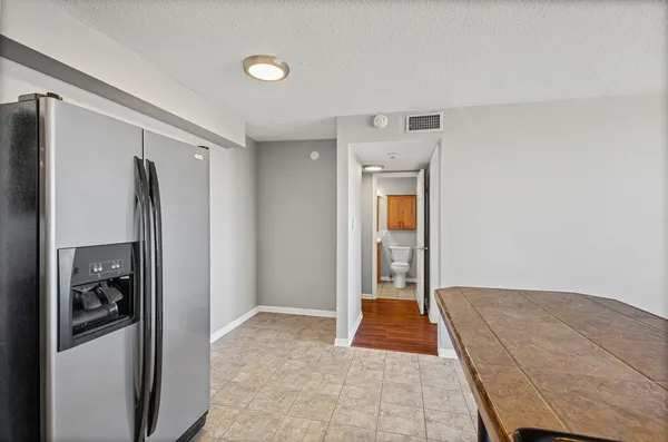 a bedroom with a bed and a refrigerator
