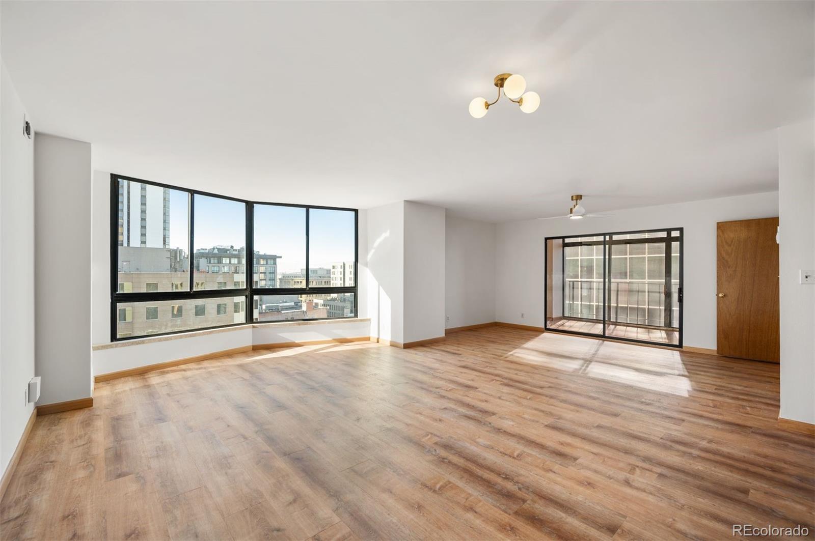 1777 Larimer Street, Unit 1010 Denver, CO 80202 - Photo 5 of 48 a view of an empty room with wooden floor and a window