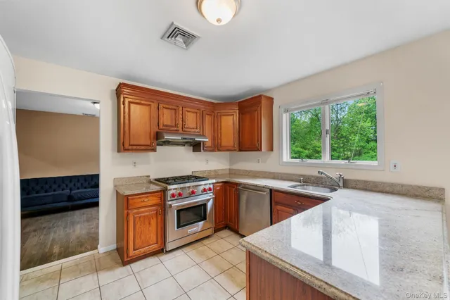 a kitchen with stainless steel appliances granite countertop a stove a sink and a microwave