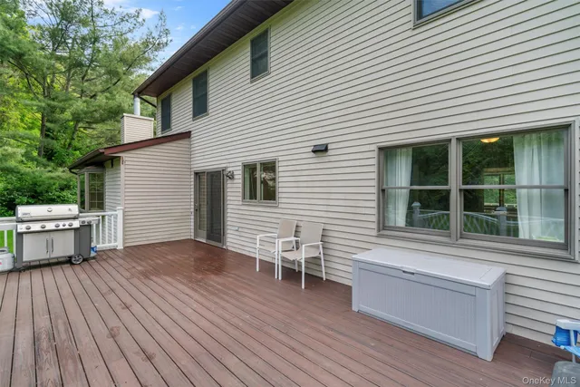 a view of a house with a deck and furniture