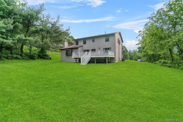 a view of a house with a big yard and large trees
