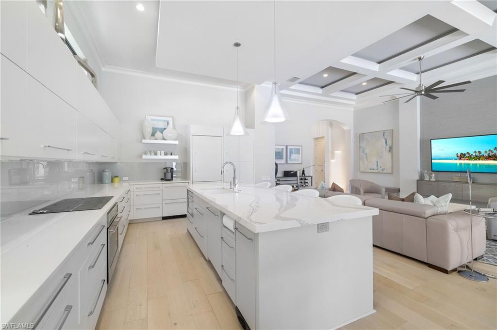 17441 Via Lugano Court Miromar Lakes, FL 33913 - Photo 13 of 40 a large white kitchen with a large window a sink and stainless steel appliances