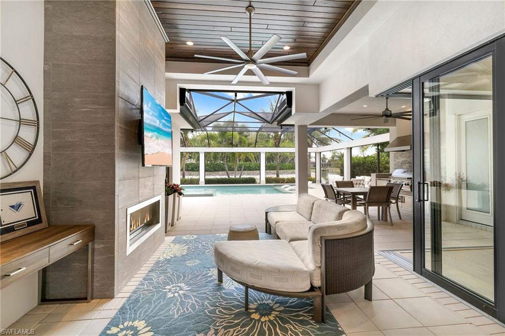 17441 Via Lugano Court Miromar Lakes, FL 33913 - Photo 24 of 40 a living room with furniture a fireplace and a table