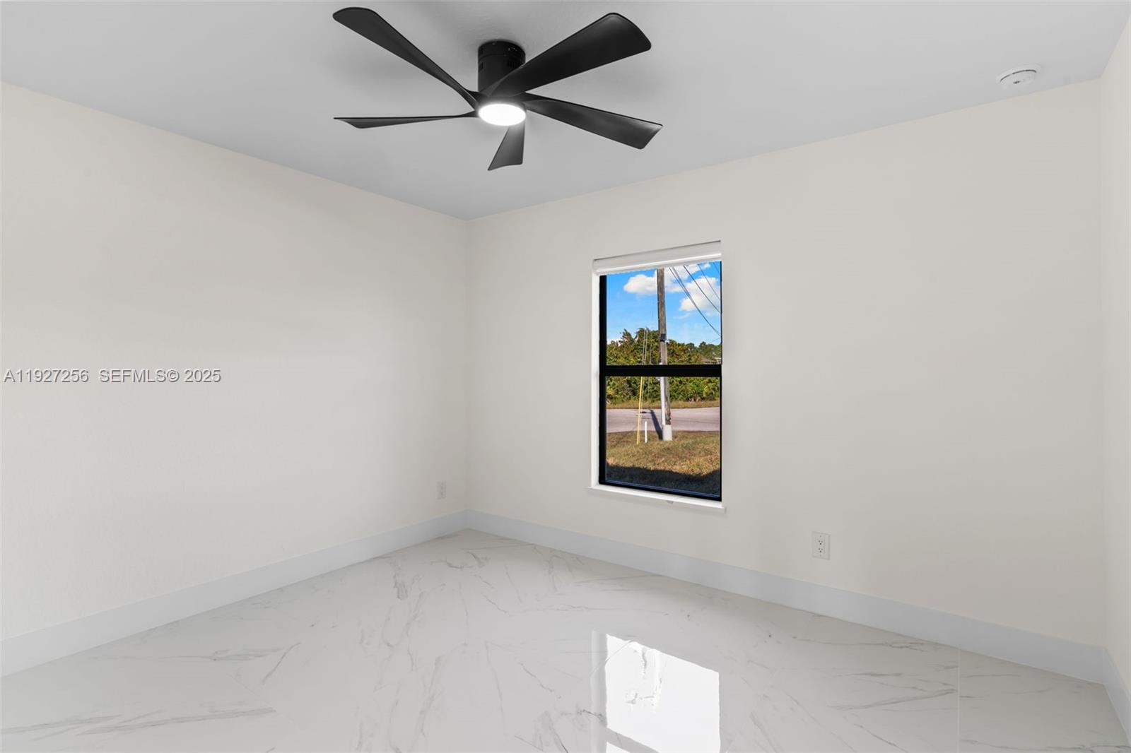 3419 16th Street Southwest Lehigh Acres, FL 33976 - Photo 12 of 46 an empty room with a window and a fan