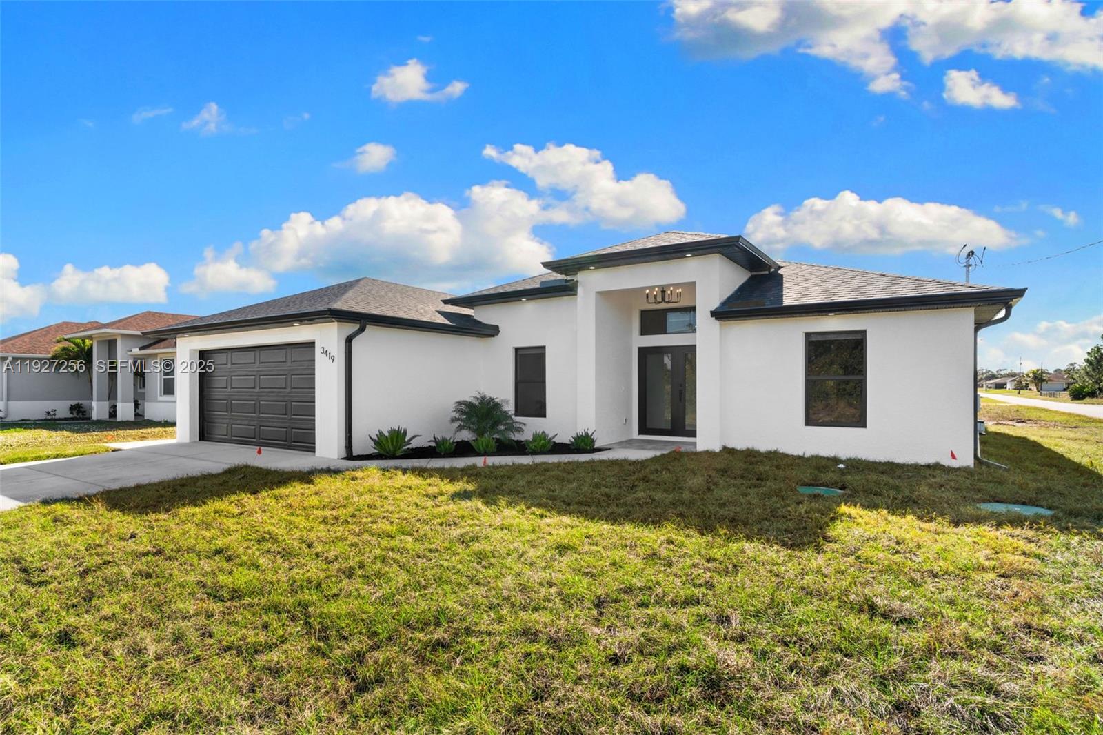 3419 16th Street Southwest Lehigh Acres, FL 33976 - Photo 2 of 46 a view of a house with a yard and garage