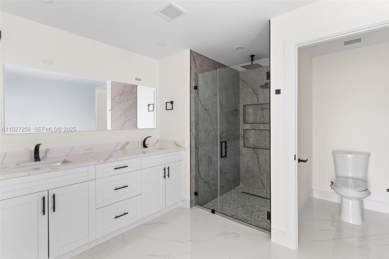 3419 16th Street Southwest Lehigh Acres, FL 33976 - Photo 22 of 46 a bathroom with a granite countertop sink a toilet and shower