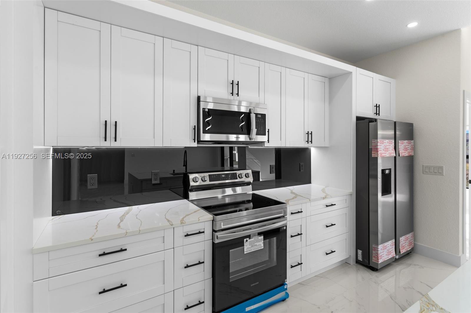 3419 16th Street Southwest Lehigh Acres, FL 33976 - Photo 8 of 46 a kitchen with granite countertop white cabinets and stainless steel appliances