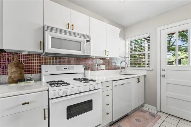 a kitchen with granite countertop cabinets and white appliances
