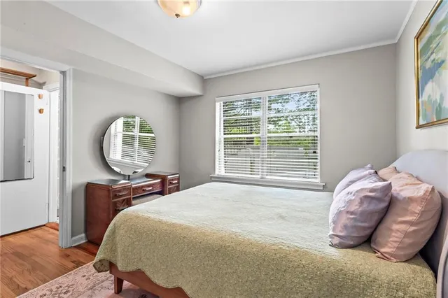 a bedroom with a bed a window and dresser