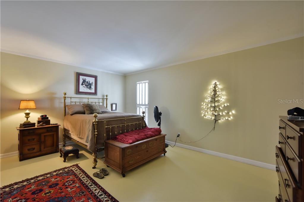 5208 Northeast 24th Street Ocala, FL 34470 - Photo 9 of 31 a bed room with a bed and a chandelier