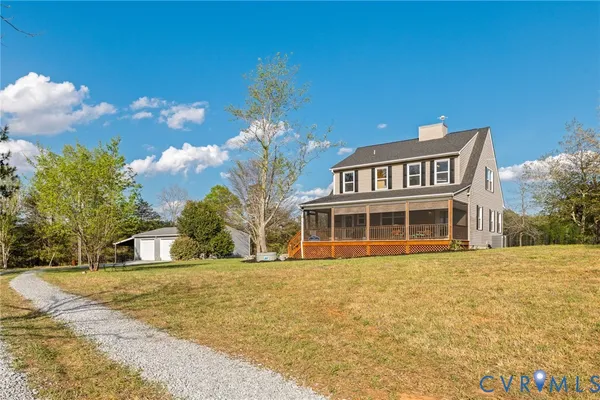 a kitchen with granite countertop a stove top oven a sink a dining table and chairs with wooden floor