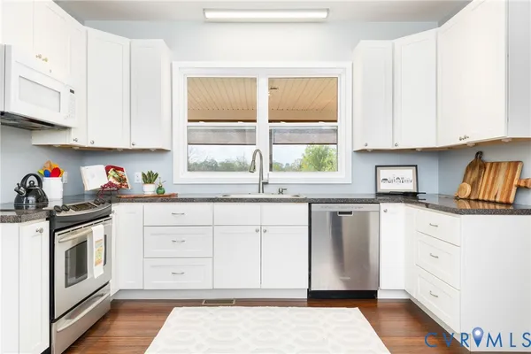 a view of a kitchen with furniture and wooden floor