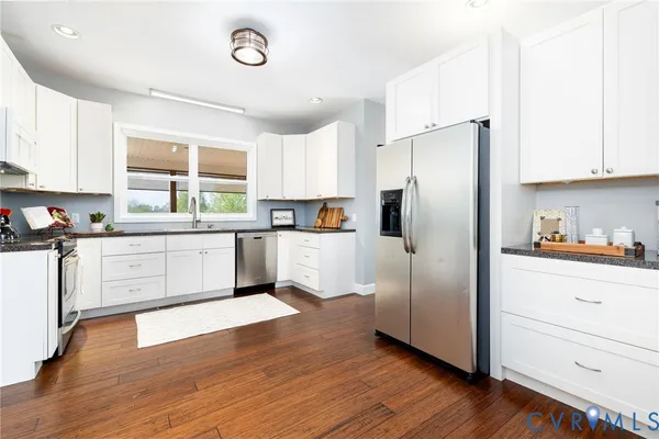 a dining room with wooden floor a chandelier a wooden table and chairs