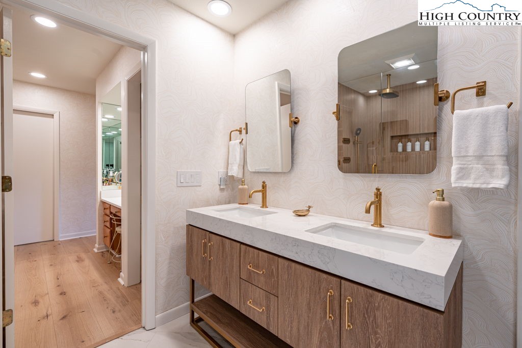 102 Ridge Drive Linville, NC 28646 - Photo 24 of 48 a bathroom with a double vanity sink a mirror and a shower