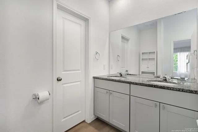a bathroom with a granite countertop sink and a mirror