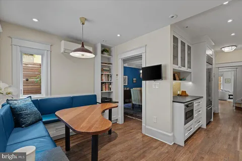 a living room with stainless steel appliances kitchen island granite countertop furniture and wooden floor