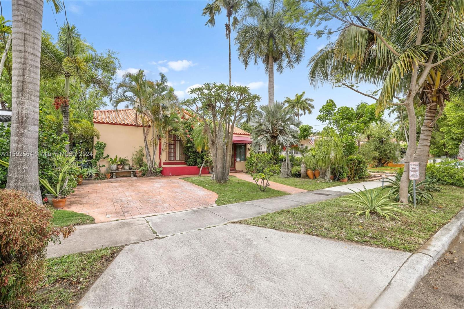 a view of a house with palm trees and a small yard