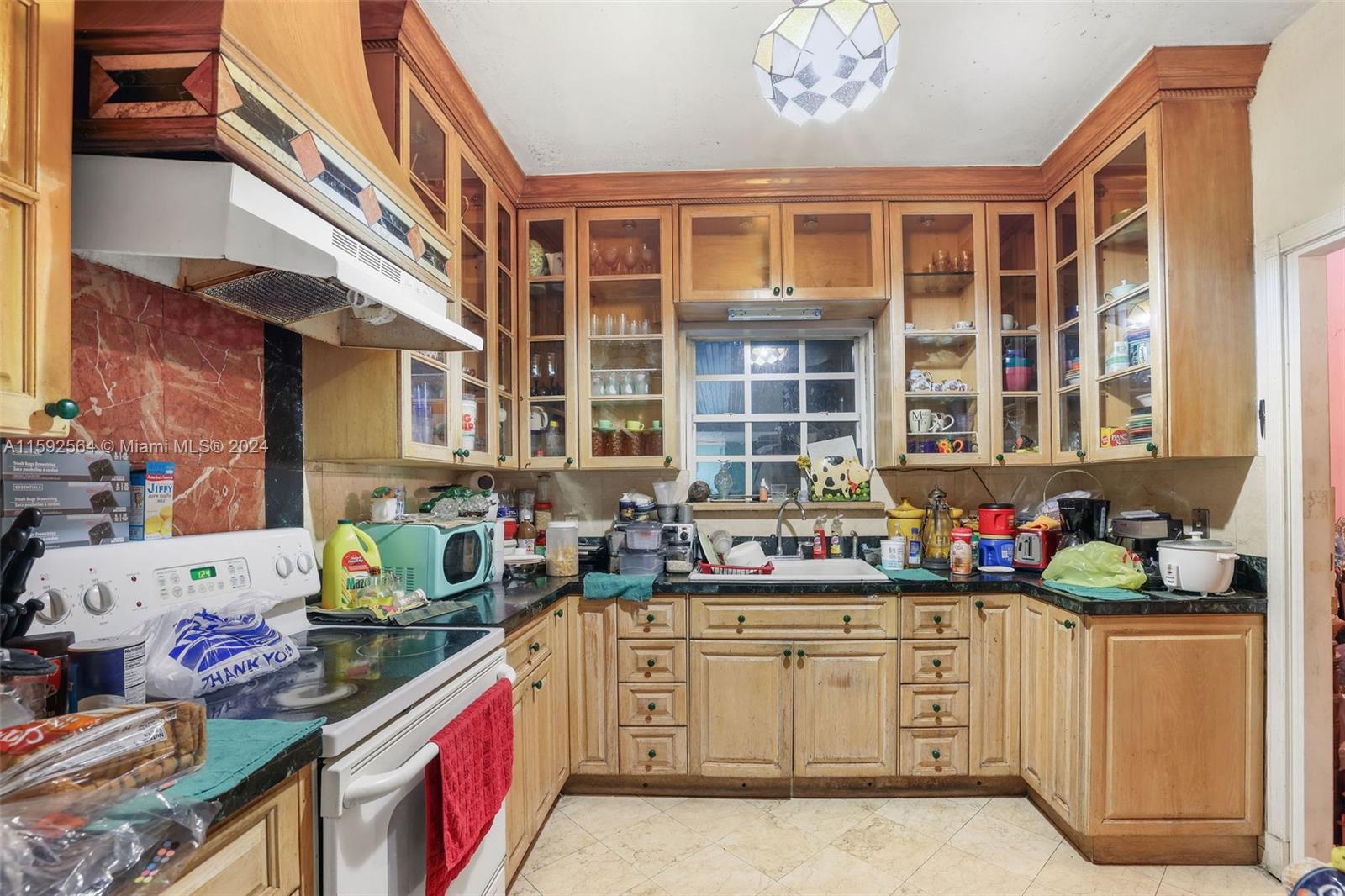445 Southwest 20th Road Miami, FL 33129 - Photo 5 of 13 a kitchen with a sink stove and cabinets