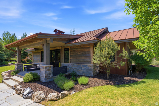1575 Old Ranch Road Park City, UT 84098 - Photo 41 of 45 Exterior featuring stone and wood siding, a standing seam metal roof, covered patio with wood beams, and a natural stone pathway