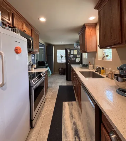 a kitchen with stainless steel appliances a stove a sink and a refrigerator