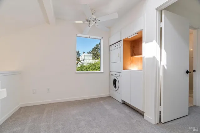 an empty room with windows and ceiling fan