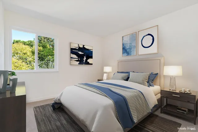 a bedroom with a bed and a lamp on dresser