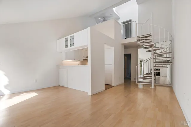 a view of a livingroom with wooden floor and staircase