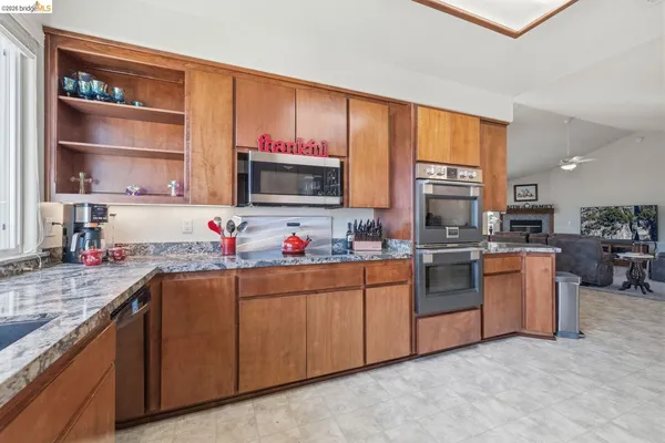 a kitchen with granite countertop a sink stainless steel appliances and cabinets