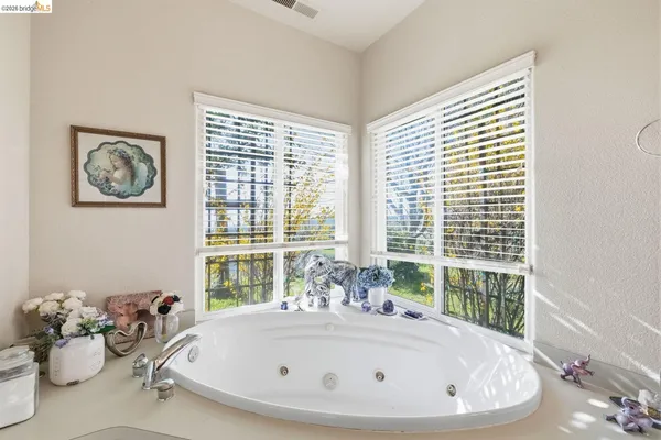 a white bath tub sitting in a bathroom next to a window