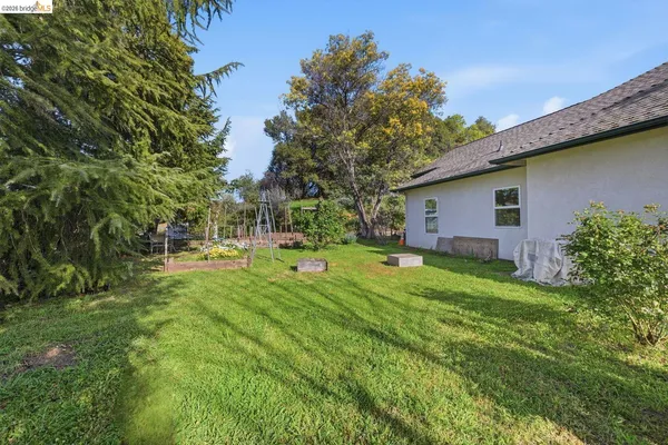 a view of a house with backyard and sitting area