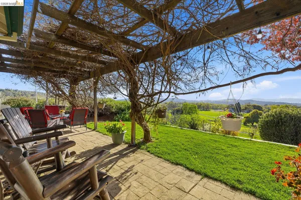 a view of a patio with table and chairs with wooden floor and fence
