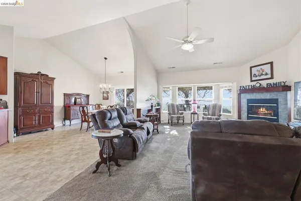 a living room with furniture a fireplace and a chandelier