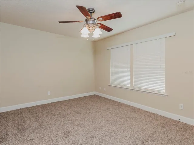 an empty room with a window and a fan