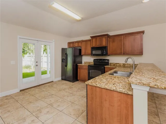 a kitchen with stainless steel appliances granite countertop a refrigerator stove top oven a sink and dishwasher