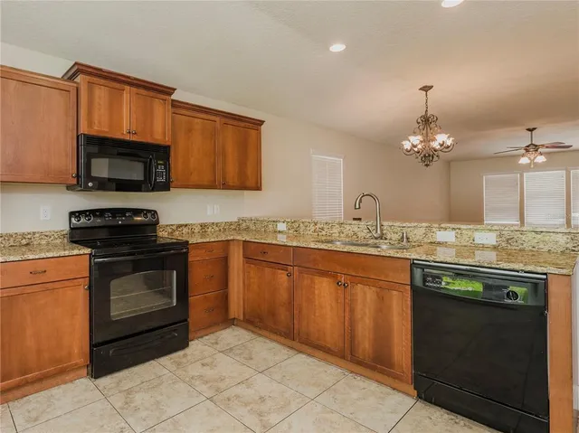 a kitchen with granite countertop a stove top oven sink and cabinets