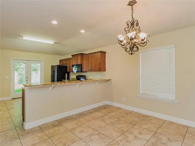 a view of a kitchen with furniture and stainless steel appliances