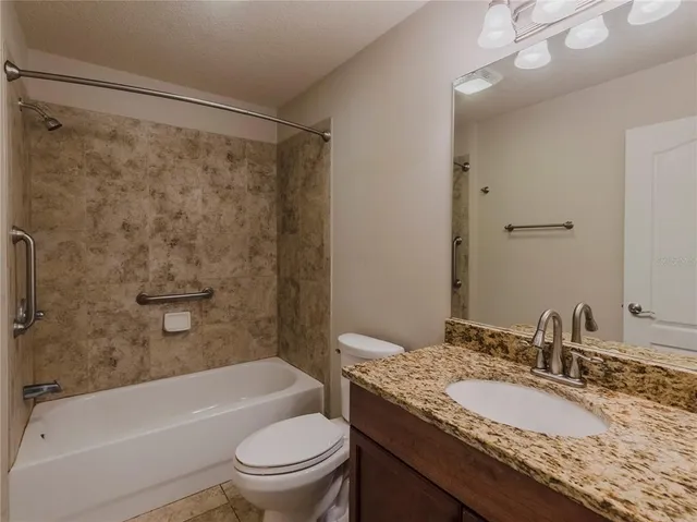 a bathroom with a granite countertop sink toilet and shower