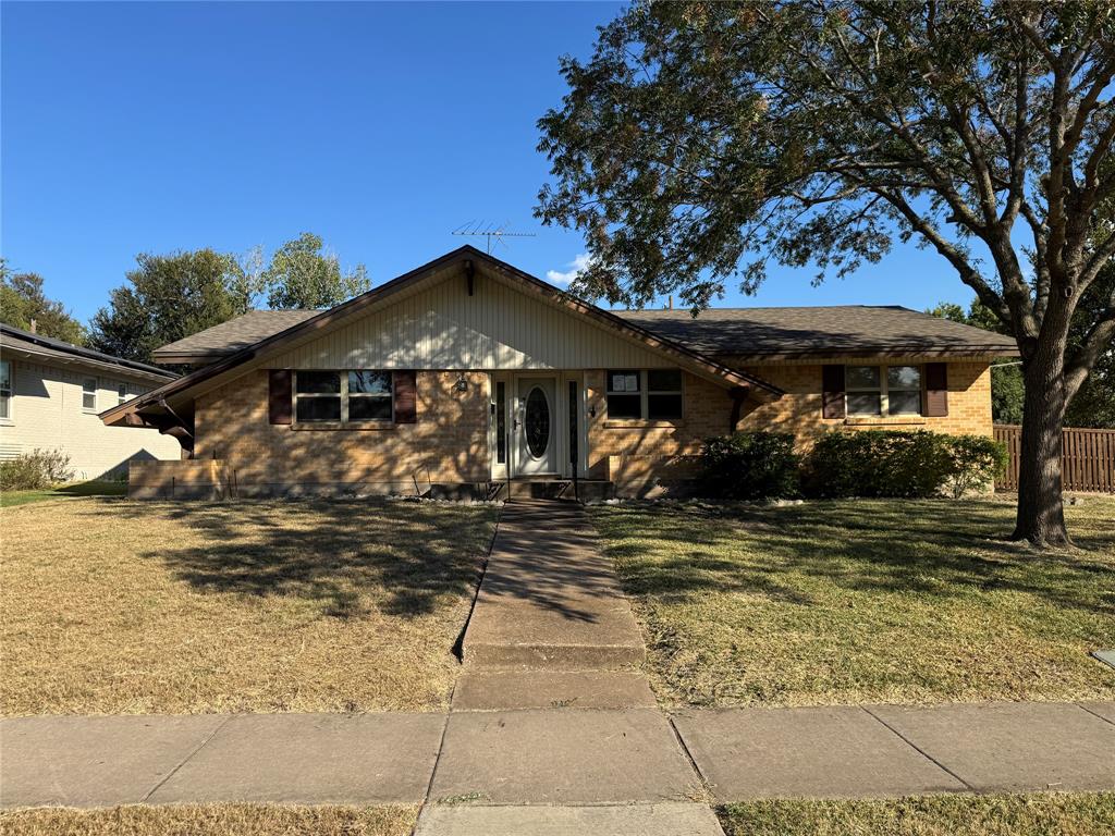 a front view of a house with a tree