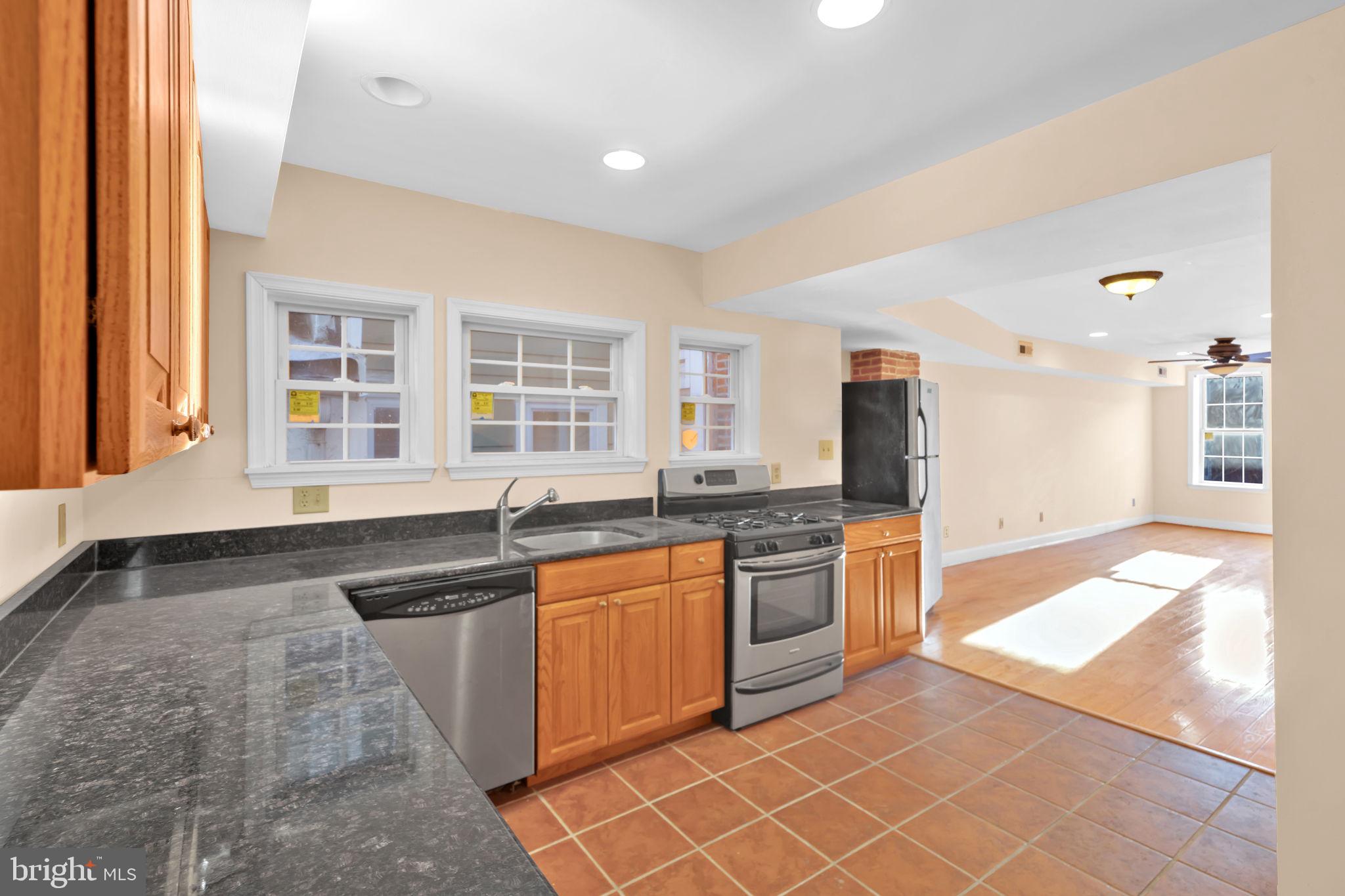 1447 William Street Baltimore, MD 21230 - Photo 26 of 65 a large kitchen with granite countertop a stove a sink and a granite counter tops