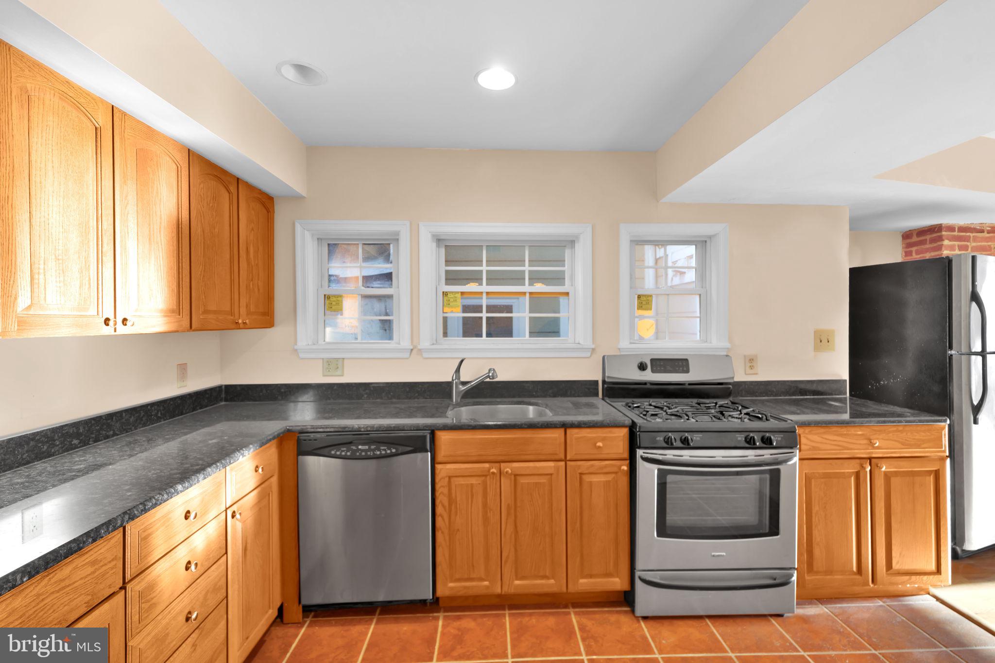 1447 William Street Baltimore, MD 21230 - Photo 27 of 65 a kitchen with granite countertop a stove sink and refrigerator