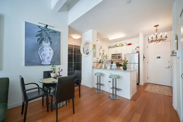 a bedroom with a bed wooden floor and a flat screen tv