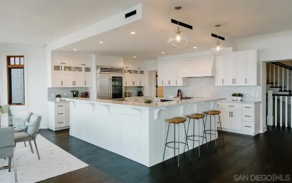 a kitchen with stainless steel appliances granite countertop a refrigerator sink and white cabinets