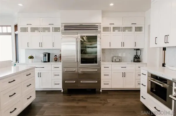 a kitchen with cabinets stainless steel appliances and a window