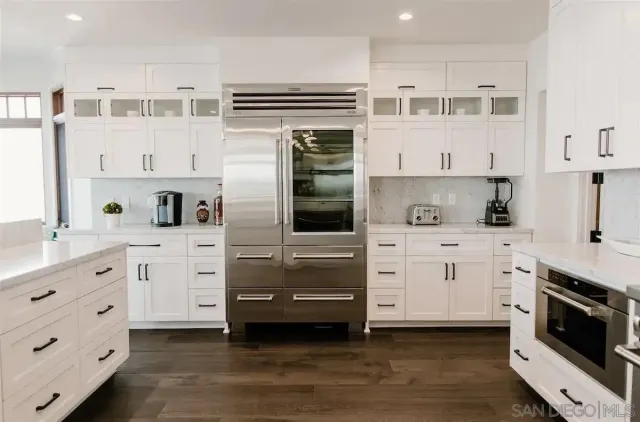 a kitchen with cabinets stainless steel appliances and a window
