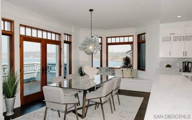 a dining room with furniture large windows and a chandelier