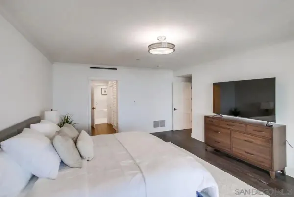 a bedroom with a bed and flat screen tv