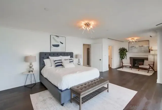 a bedroom with a bed a table and a fireplace